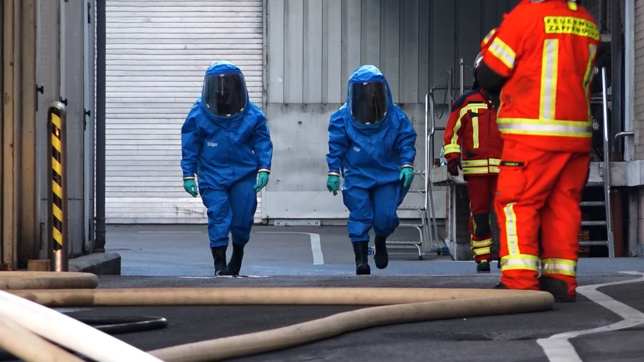 Einsatzkräfte in Chemikalienschutzanzügen.