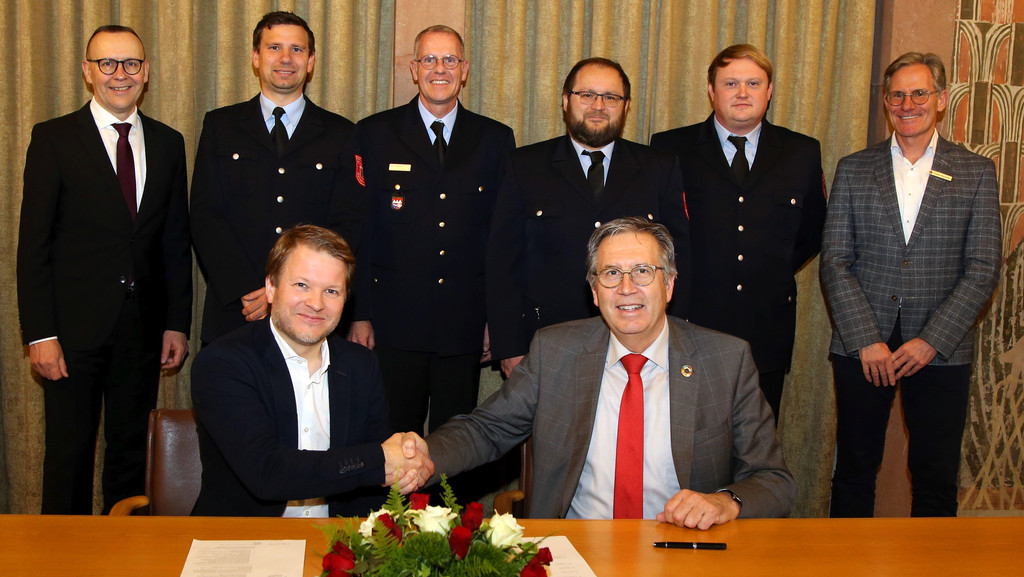 Sebastian Müller und Oberbürgermeister Jürgen Herzing unterzeichneten im Beisein von Vertretern der Feuerwehr und der Sparkasse die Vereinbarung über die Feuerwehrrente.