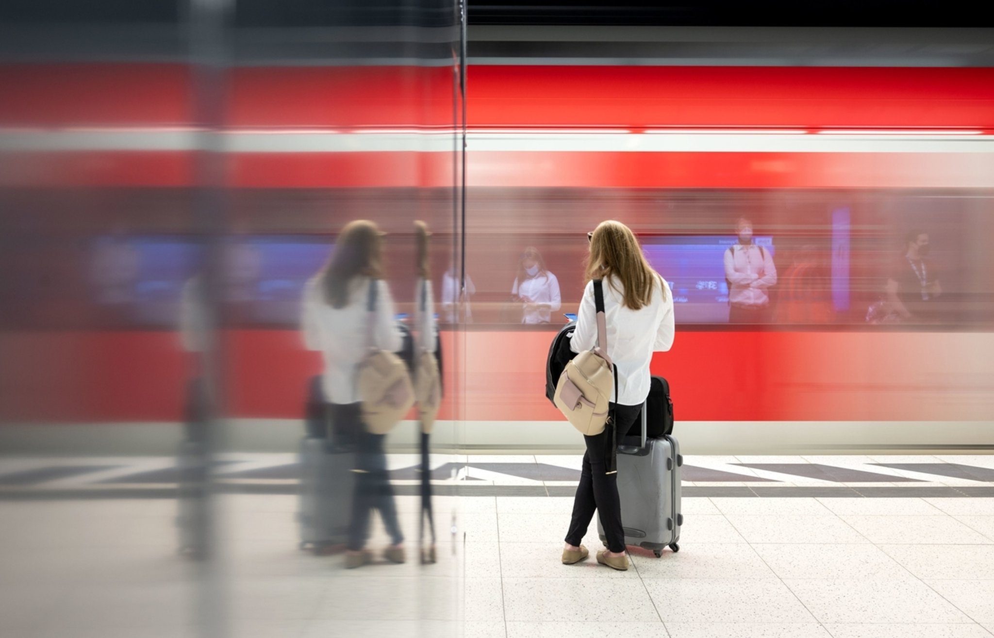 Eine Frau steht an einem Gleis vor einer S-Bahn. Mit speziellen 9-Euro-Monatstickets sollen Millionen Menschen im Juni, Juli und August überall in der Republik in Bus und Bahn steigen können. 