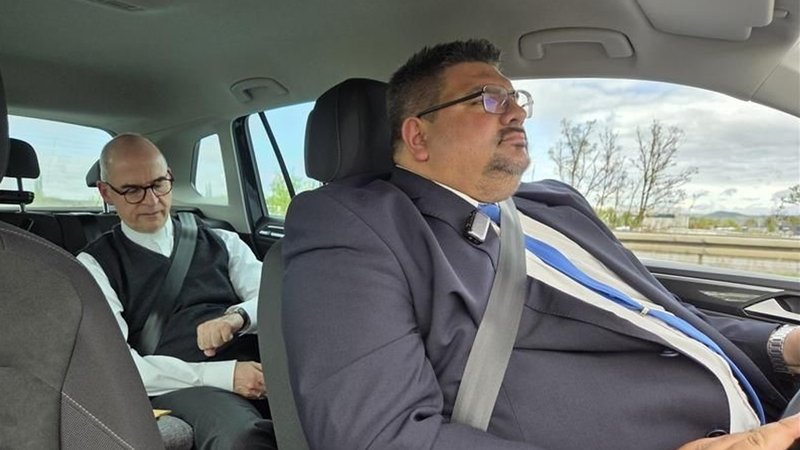 Dominik Zeißner sitzt am Steuer eines Autos. Auf dem Rücksitz sitzt der Würzburger Bischof Franz Jung. | Bild: BR/Conny Kleinschroth Dominik Zeißner sitzt am Steuer eines Autos. Auf dem Rücksitz sitzt der Würzburger Bischof Franz Jung.