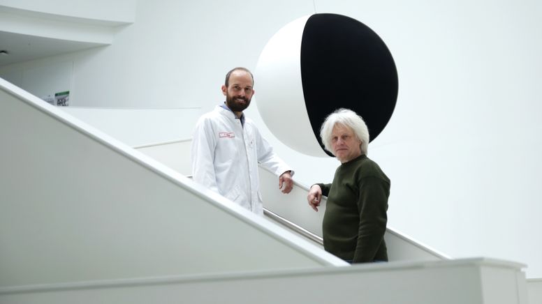 Wissenschaftler Tobias Utikal und Künstler Raimund Ritz stehen vor dem Kunstwerk "Black hole Sun".  | Bild:BR / Isabel Pogner