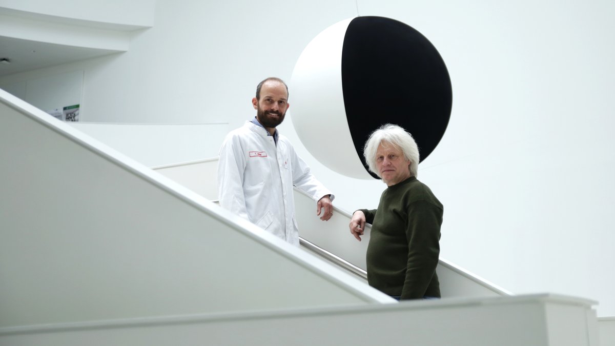 Wissenschaftler Tobias Utikal und Künstler Raimund Ritz stehen vor dem Kunstwerk "Black hole Sun". 