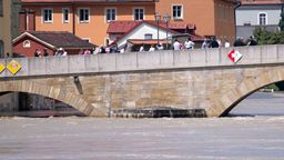 Regensburg: Menschen stehen in der Altstadt auf der Steinernen Brücke und schauen sich das Hochwasser an. | Bild:dpa-Bildfunk/Sven Hoppe