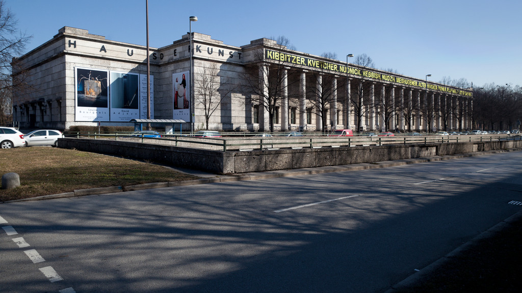 Zu sehen ist das Haus der Kunst in München an einer Straße bei gutem Wetter.