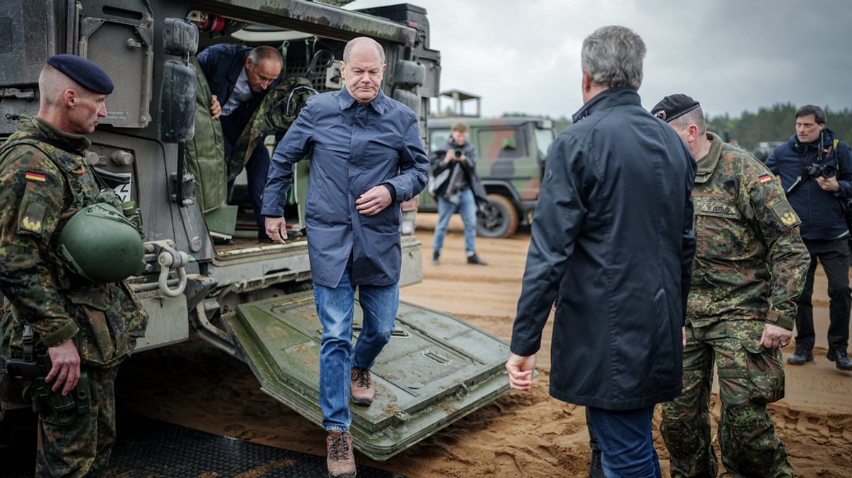 Bundeskanzler Olaf Scholz (SPD) steigt neben dem litauischen Staatspräsidenten Gitanas Naueda bei dem Besuch der Nato-Übung Quadriga 24 aus einem Radpanzer vom Typ Boxer der Bundeswehr.