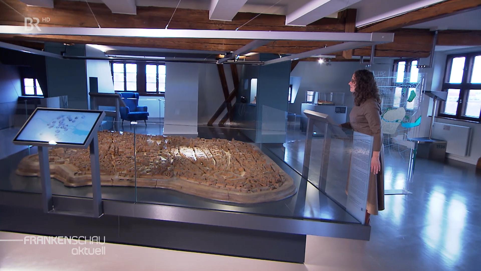 Frau steht vor Modell von Nürnberg.