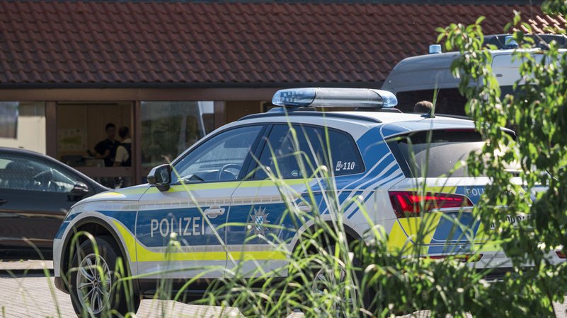 Ein Polizeifahrzeug steht auf dem Gelände des regionalen Netzbetreibers Überlandwerk Rhön. Ein 21-Jähriger hat in der Firma eine Kollegin getötet und zwei weitere Mitarbeiter schwer verletzt. | Bild: dpa-Bildfunk/Daniel Vogl Ein Polizeifahrzeug steht auf dem Gelände des regionalen Netzbetreibers Überlandwerk Rhön. Ein 21-Jähriger hat in der Firma eine Kollegin getötet und zwei weitere Mitarbeiter schwer verletzt.