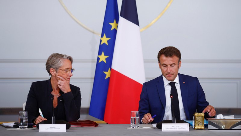 Archivbild: Elisabeth Borne, Premierministerin von Frankreich, und Emmanuel Macron, Präsident von Frankreich, sitzen nebeneinander vor der EU- und Frankreichflagge