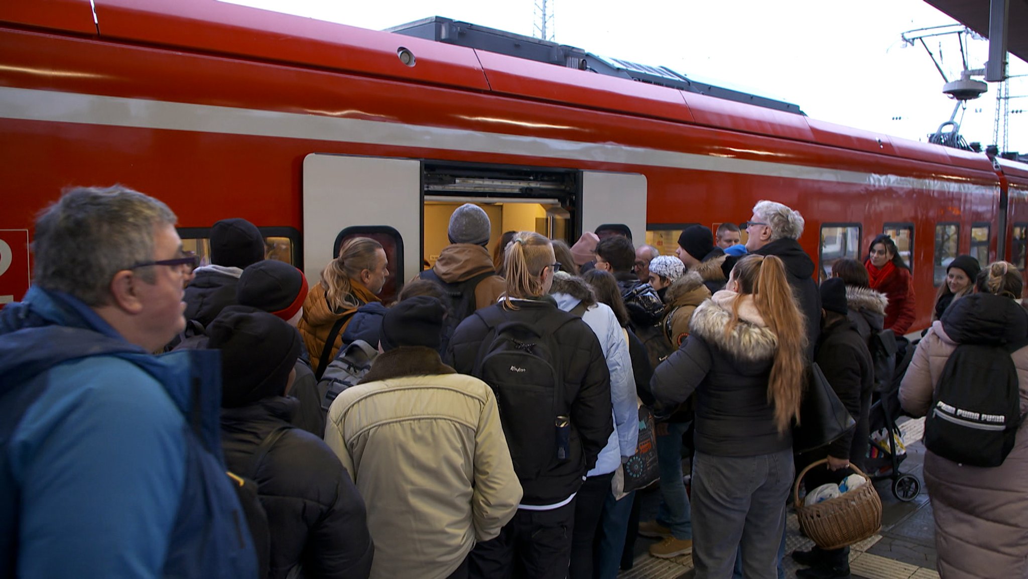 Viele Menschen wollen in einen Zug einsteigen. 