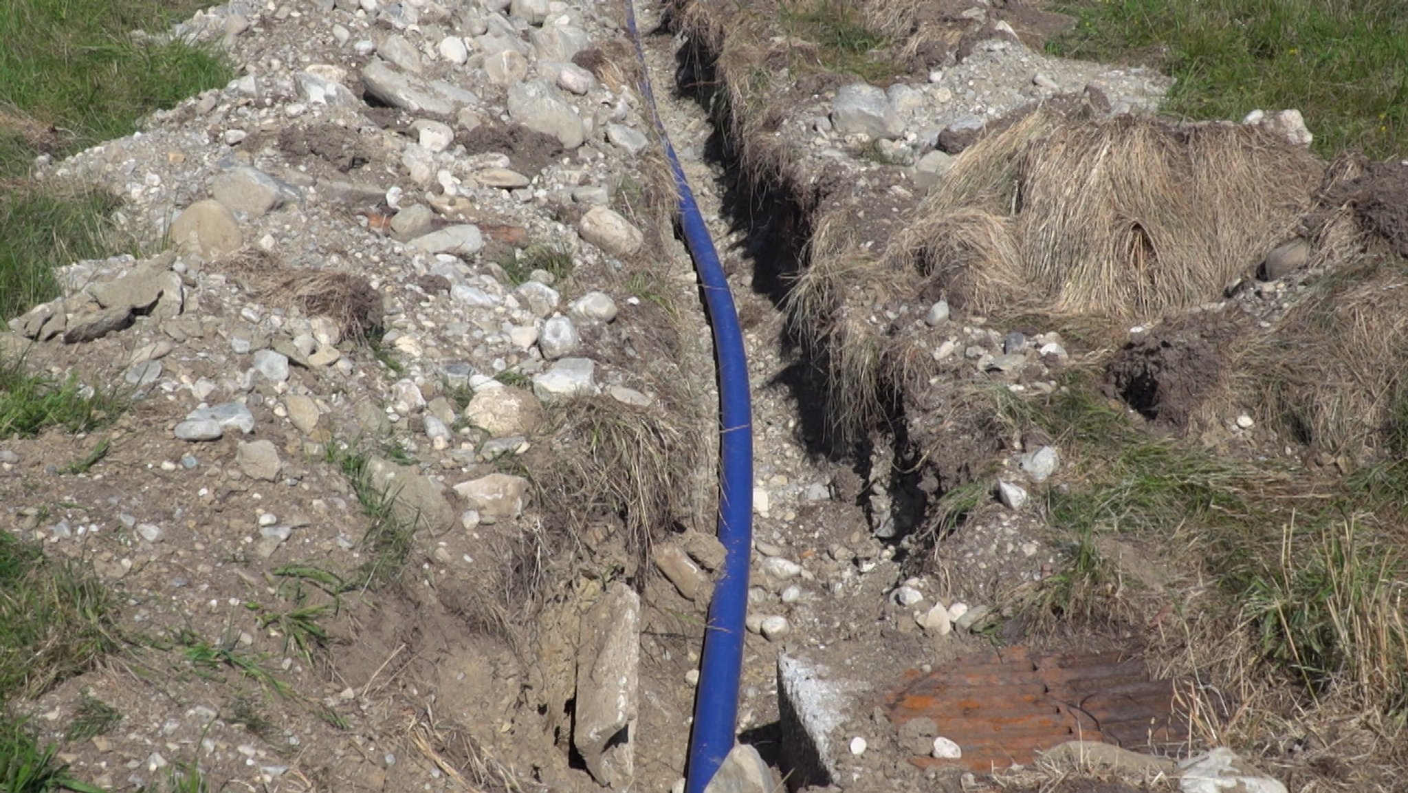 Eine blaue Wasserleitung aus Kunststoff in einem offenen Graben | Bild: BR / Martin Breitkopf Eine blaue Wasserleitung aus Kunststoff in einem offenen Graben