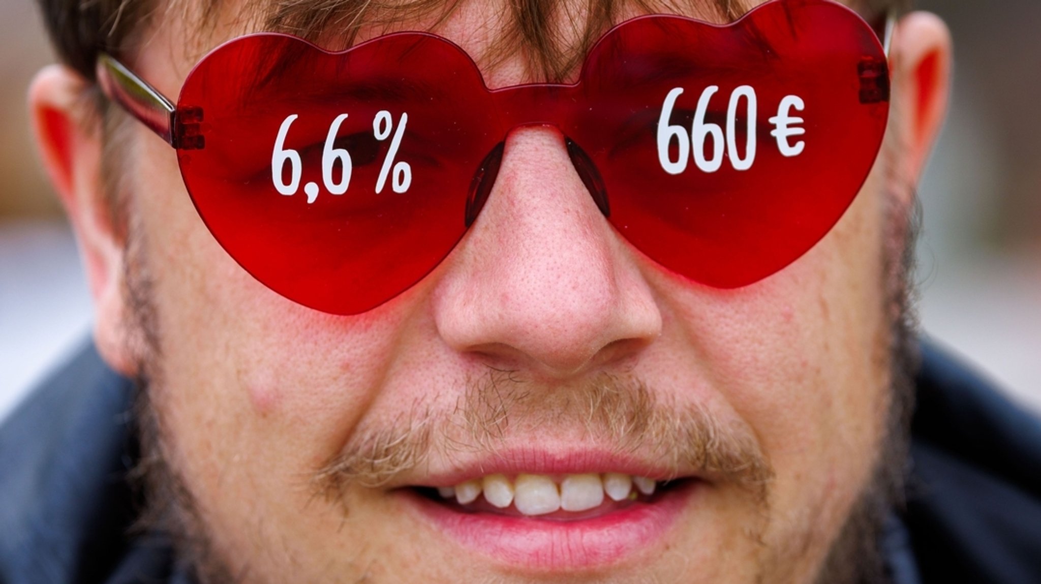 Ein Telekom-Mitarbeiter trägt bei der zentralen Kundgebung von Verdi Nord eine Brille mit den aktuellen Tarifforderungen. 