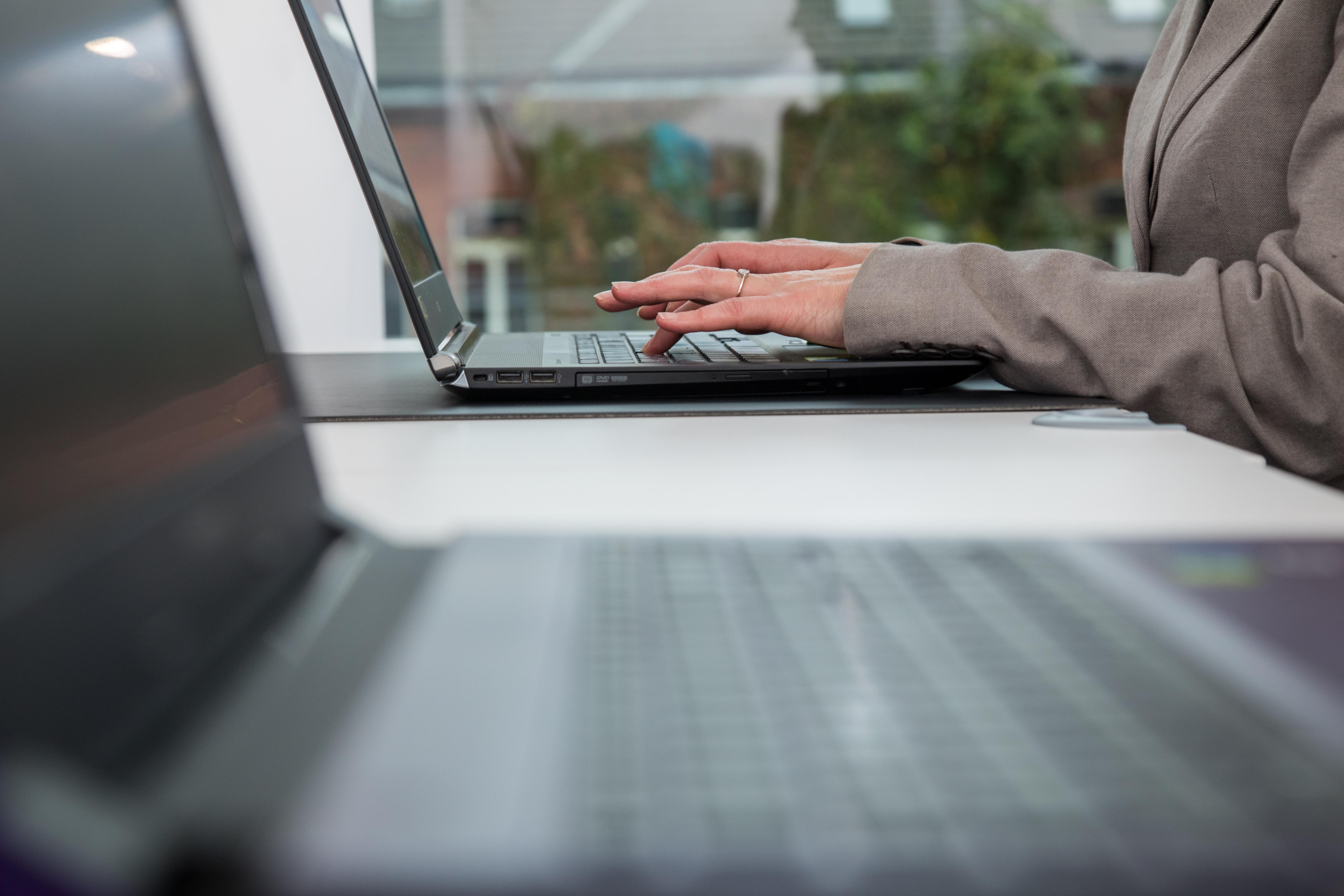 Frau trägt Blazer und sitzt am Laptop