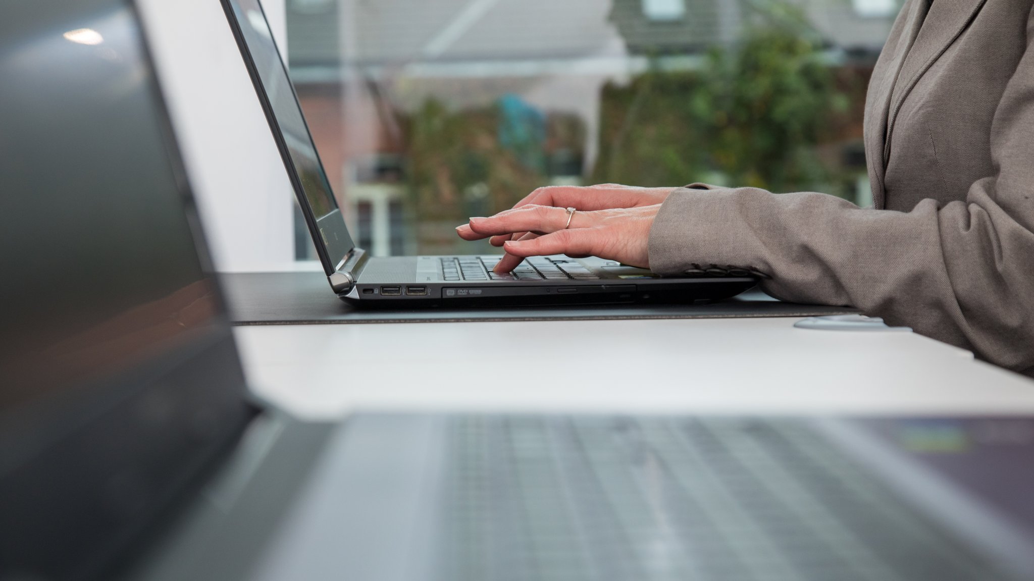 Frau trägt Blazer und sitzt am Laptop