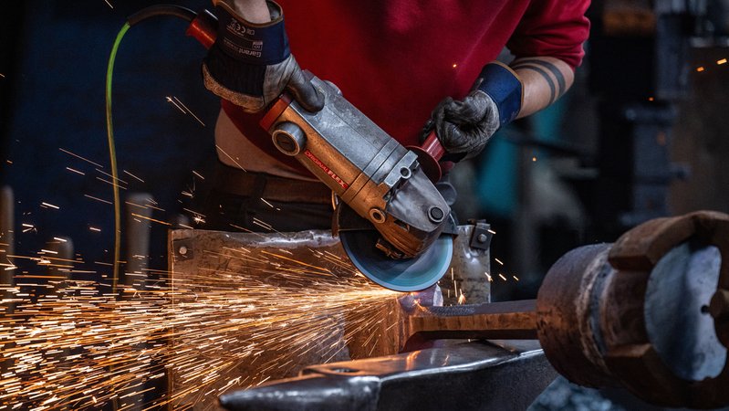 Ein Mitarbeiter vom Rottaler Hammerwerk bearbeitet mit einem Winkelschleifer einen Glockenklöppel. | Bild: picture alliance/dpa | Armin Weigel Ein Mitarbeiter vom Rottaler Hammerwerk bearbeitet mit einem Winkelschleifer einen Glockenklöppel.