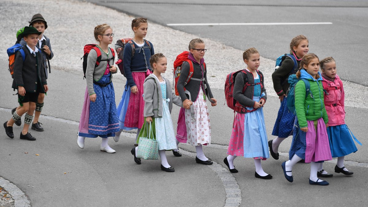Kinder in bayerischer Tracht gehen als Gruppe zur Talstation der Zugspitzbahn (Symbolbild).