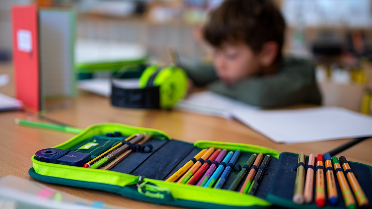 Ein Junge einer 2. Klasse arbeitet in einer Grundschule im Klassenzimmer an einem Arbeitsblatt.
