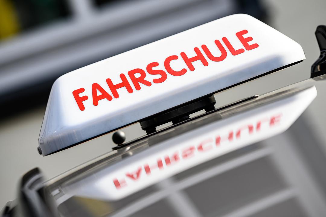 Nahaufnahme eines Autodachs, darauf ein Schild mit dem Hinweis: Fahrschule