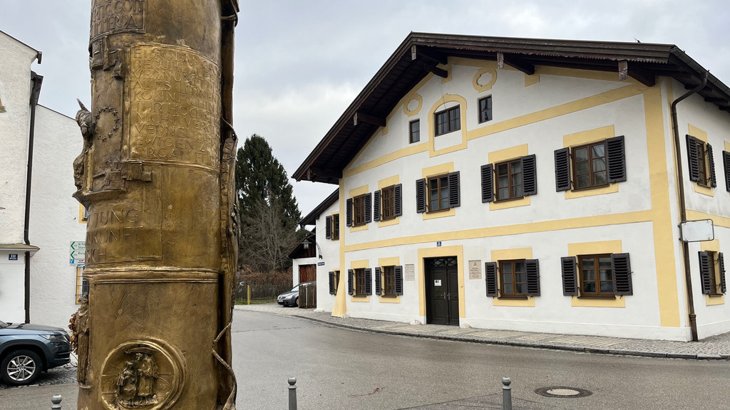 Auf dem Bild sind das Geburtshaus des emeritierten Papstes und eine goldene Steele zu sehen. | Bild: BR / Christina Schmitt Auf dem Bild sind das Geburtshaus des emeritierten Papstes und eine goldene Steele zu sehen.