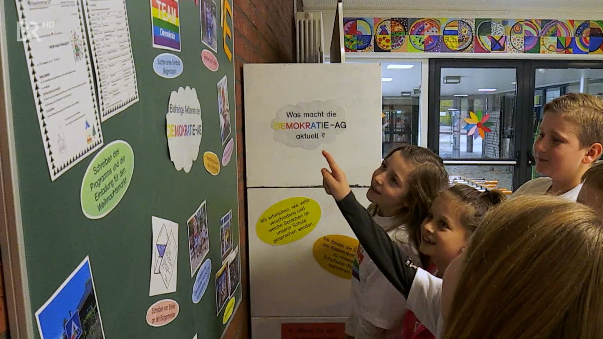 Schüler betrachten eine Collage zum Thema Demokratie.