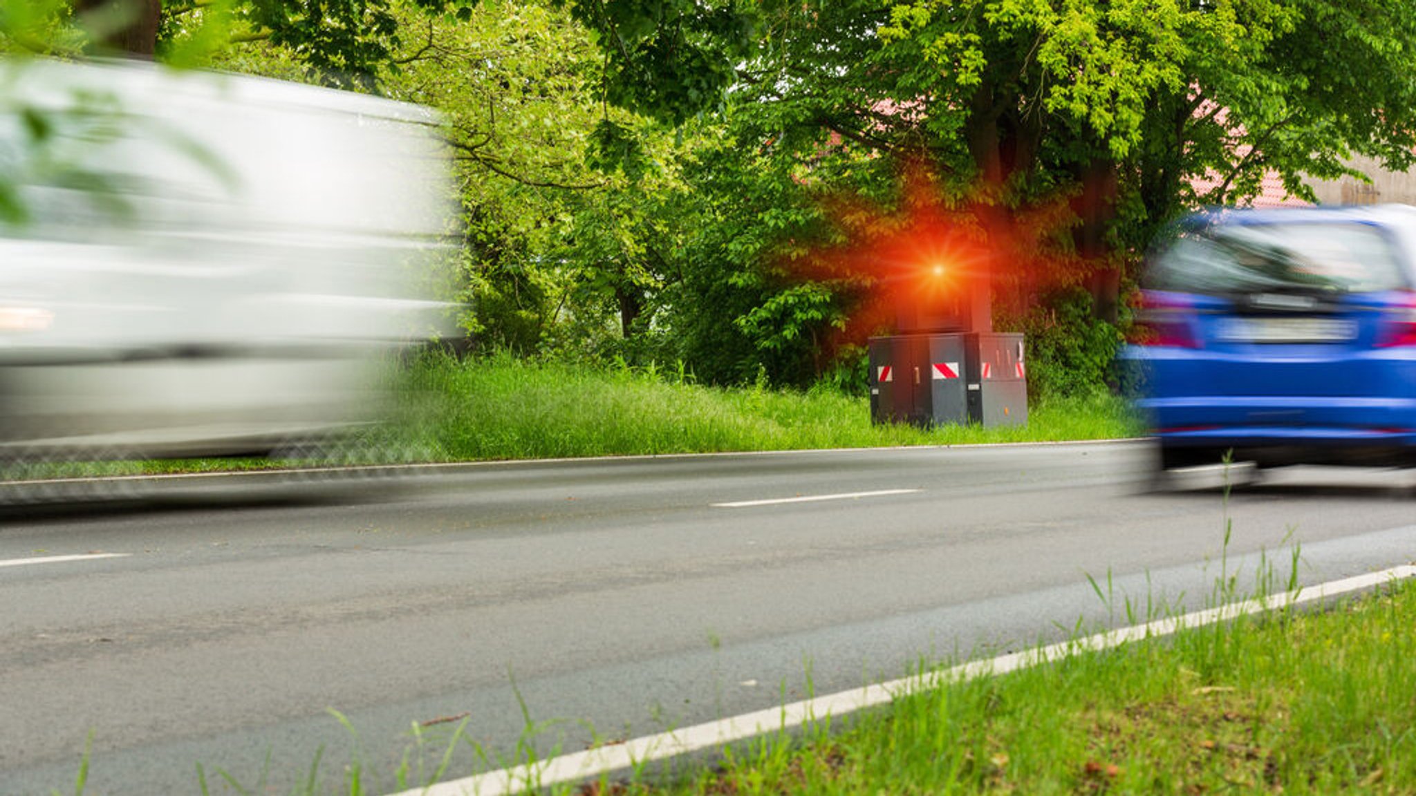 Geschwindigkeitskontrolle mit einem ausgelösten Blitzer an einer Landstraße.