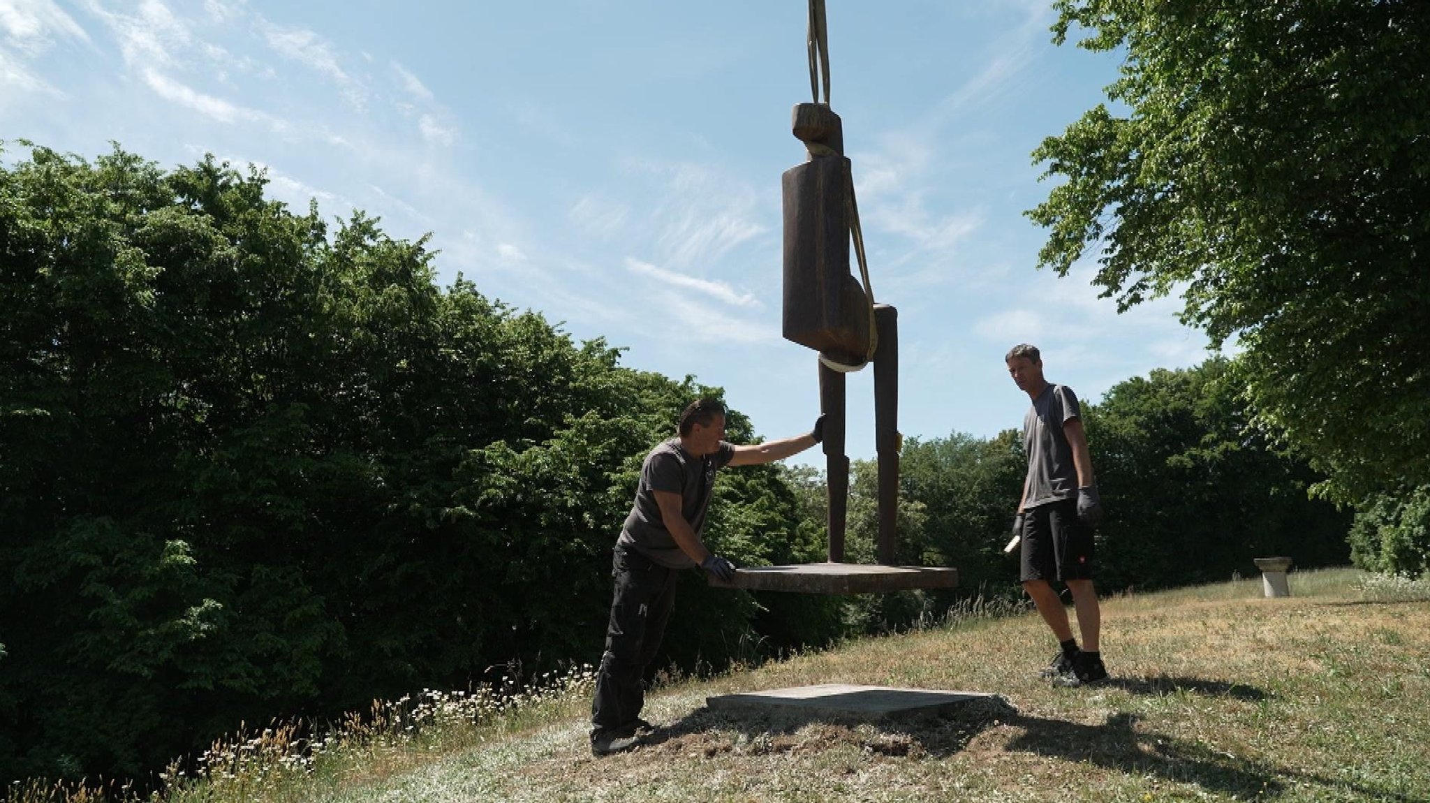 Arbeiter stellen die Skulpturen des Bildhauers Fritz Koenig auf dem weitläufigen Ganslberg-Gelände auf.