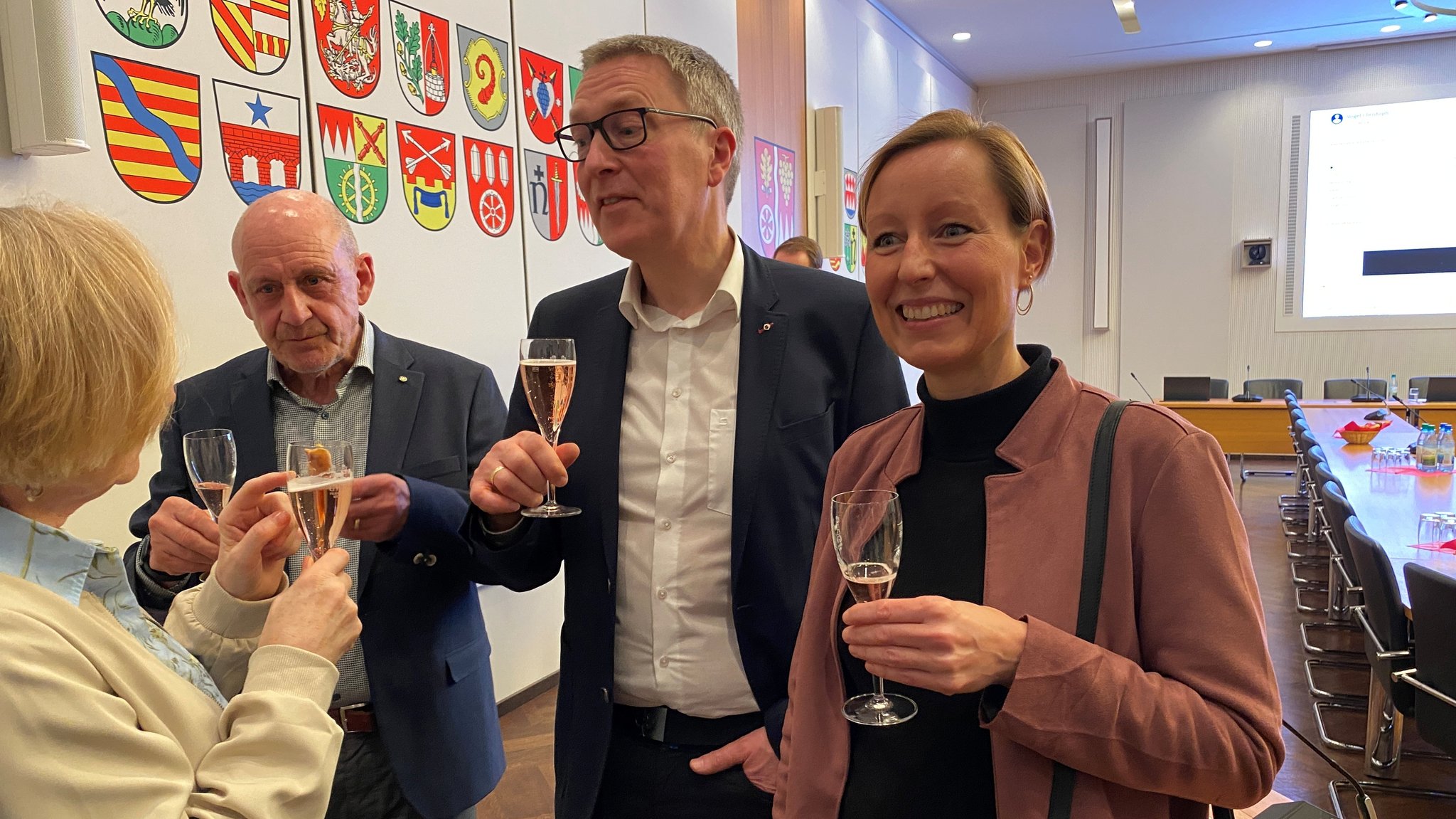 Christoph Vogel (Freie Wähler, zweiter von rechts) ist neuer Landrat in Main-Spessart. Hier trinkt er Sekt mit seiner Frau (rechts von ihm) und anderen. | Bild: BR/Markus Klingele Christoph Vogel (Freie Wähler, zweiter von rechts) ist neuer Landrat in Main-Spessart. Hier trinkt er Sekt mit seiner Frau (rechts von ihm) und anderen.