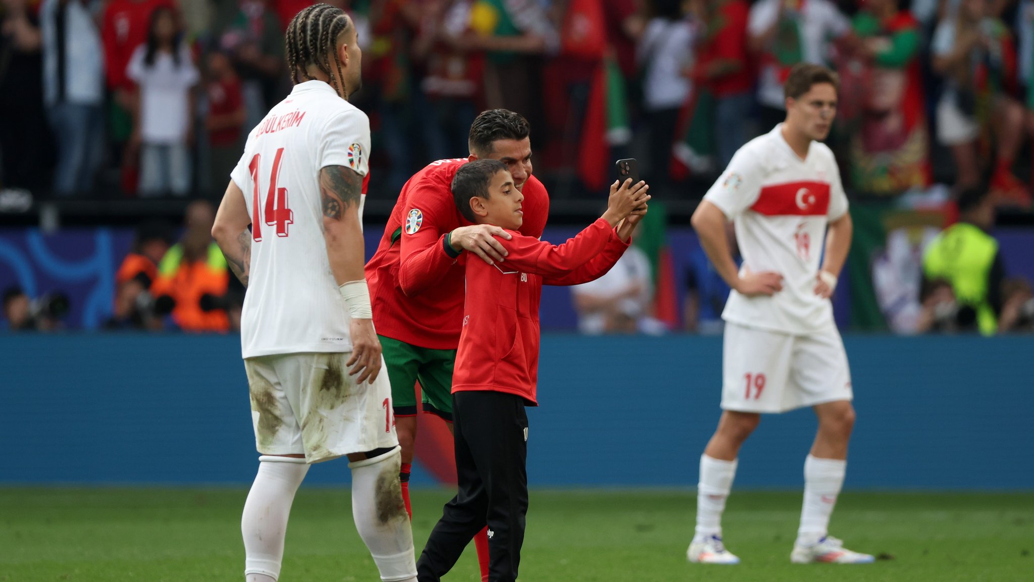 Ein Junge, der als Flitzer auf das Spielfeld gerannt ist, macht mit Portugals Cristiano Ronaldo ein Selfie.