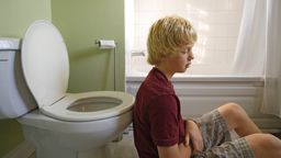 Junge sitzt mit dem Rücken auf dem Boden vor einer Toilettenschüssel | Bild:picture alliance / Bildagentur-online/Morozova | Morozova/Bildagentur-online