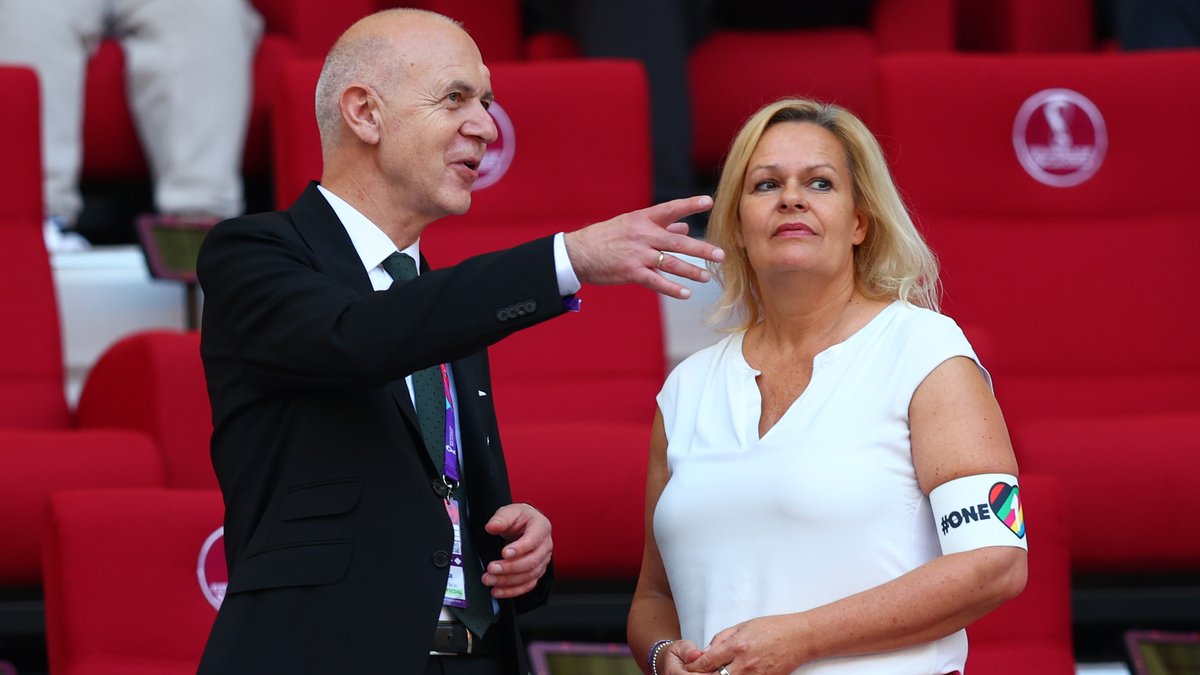 Bundesinnenministerin Nancy Faeser und der DFB-Präsident Bernd Neuendorf unterhalten sich. Die Ministerin trägt eine Armbinde mit der Aufschrift "One Love". 