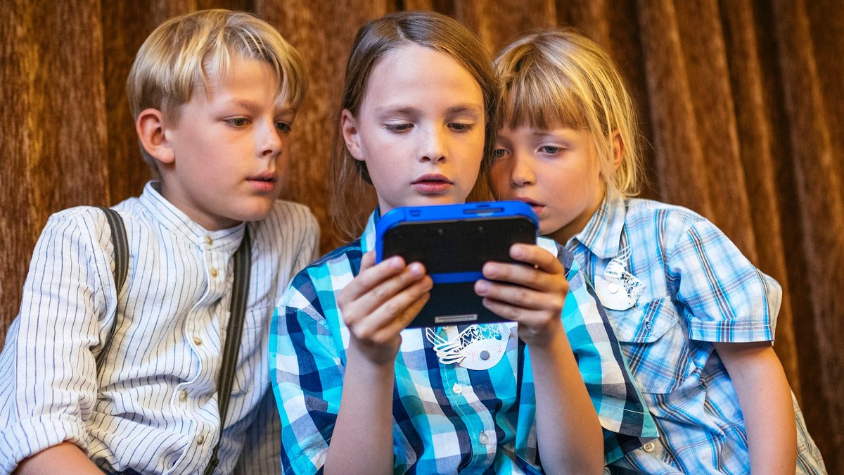 Drei Kinder mit einem Smartphone