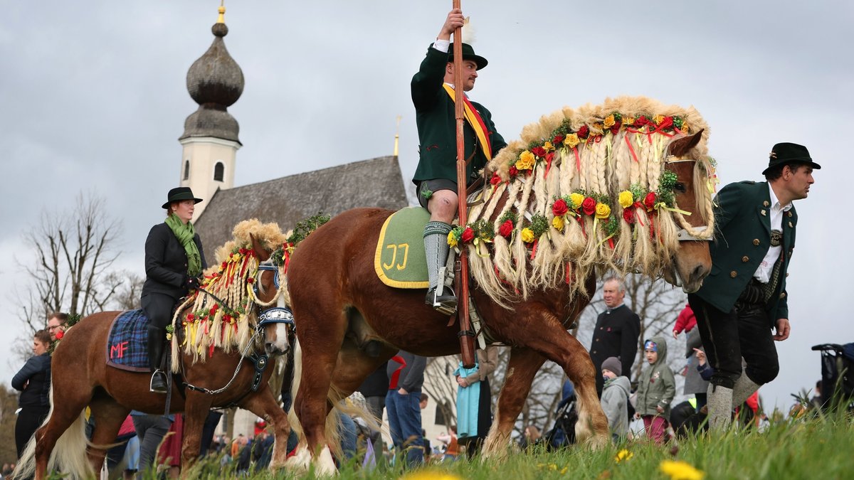Festlich geschmückte Rösser ziehen am Ostermontag beim traditionellen Georgi-Ritt in Traunstein zur Kirche von Ettendorf