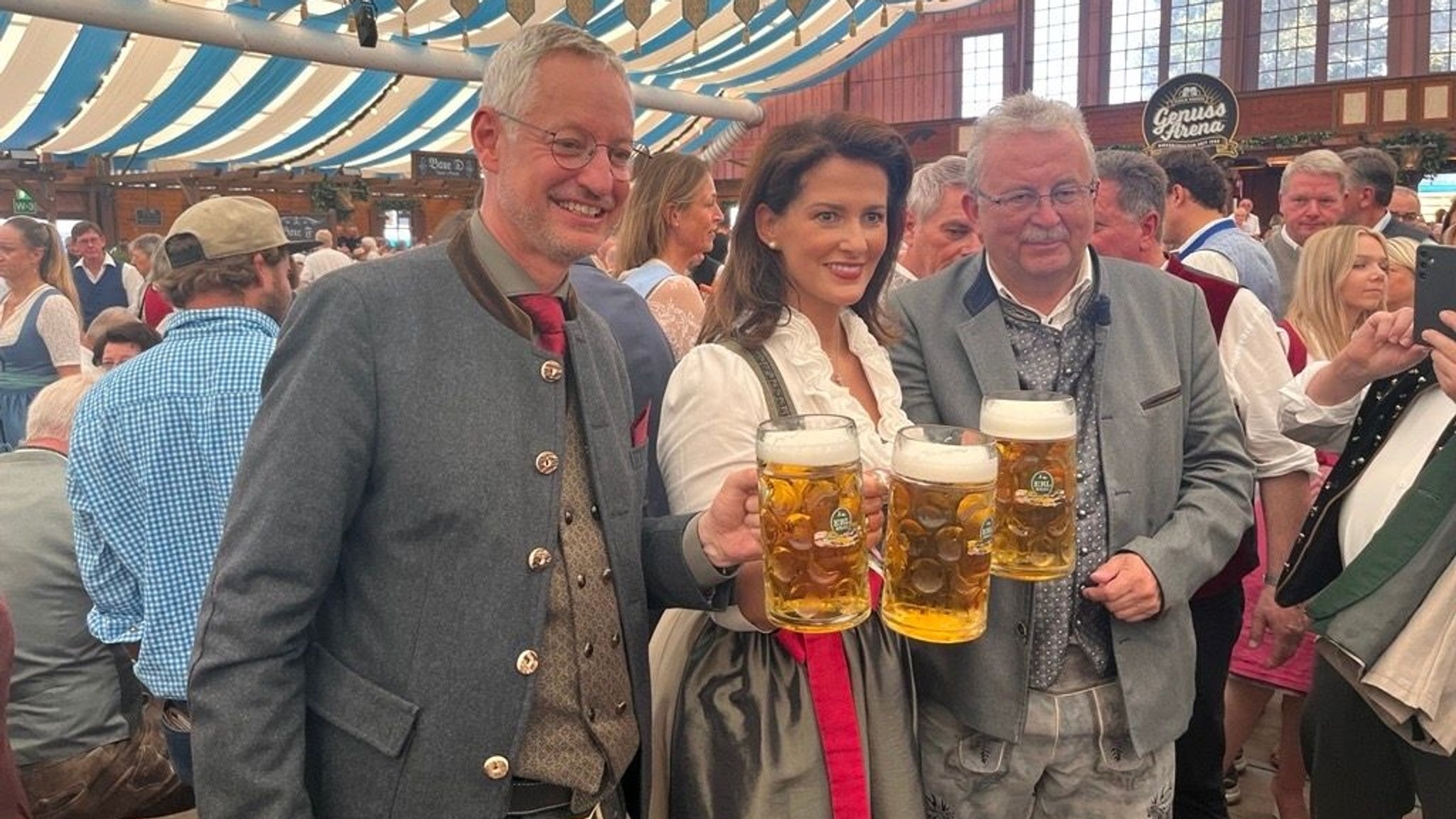 Die bayerische Landwirtschaftsministerin Kaniber steht mit Straubings OB Pannermayr und Landrat Laumer in einem Festzelt. Alle drei halten eine Maß Bier.