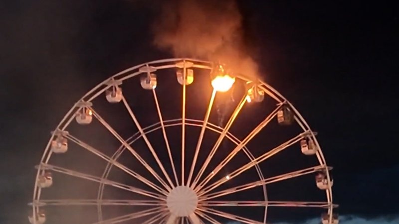 Das Leipziger Riesenrad mit einer brennenden Gondel vor dem Nachthimmel | Bild: Bayerischer Rundfunk 2024 Das Leipziger Riesenrad mit einer brennenden Gondel vor dem Nachthimmel
