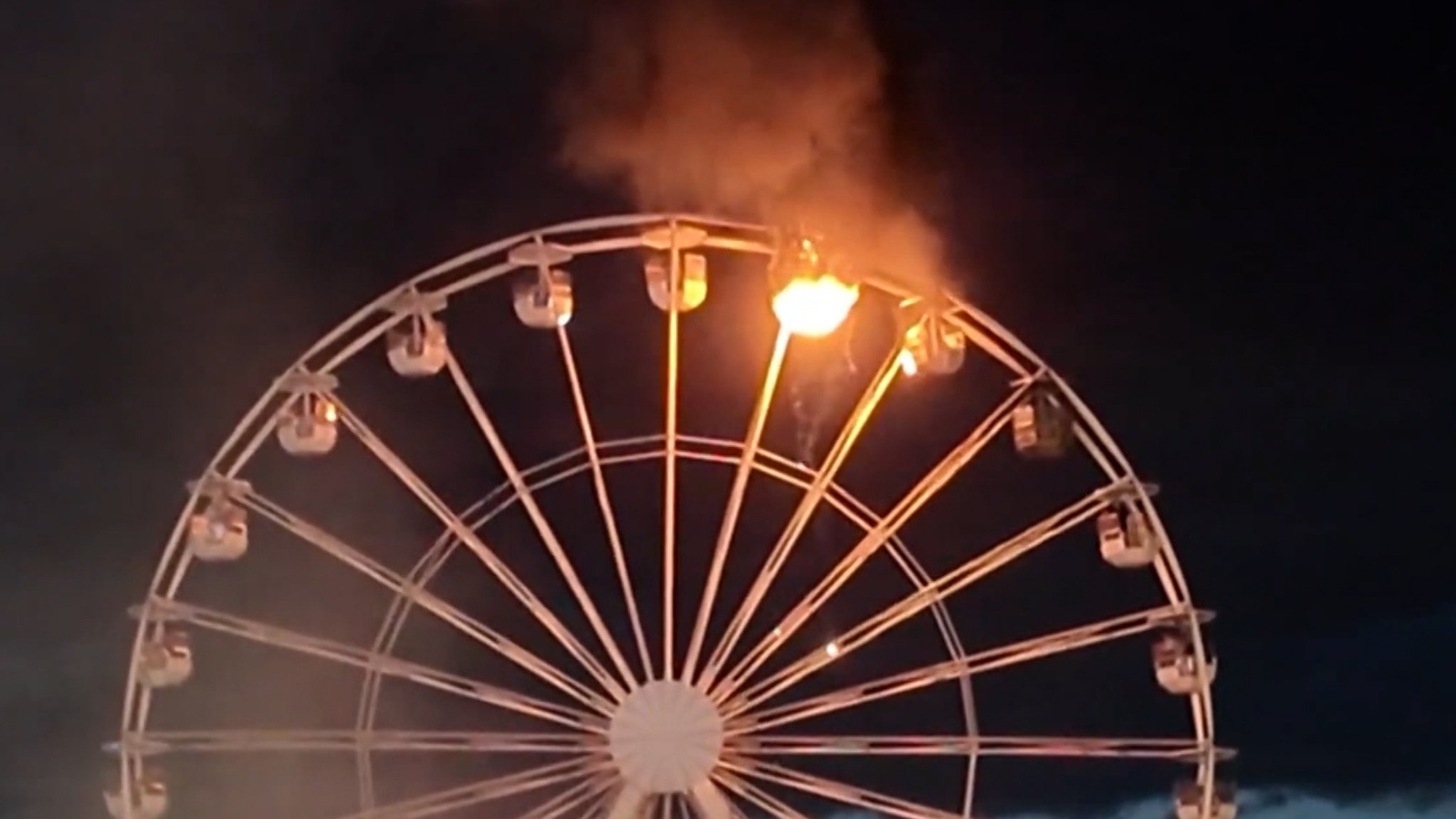 Das Leipziger Riesenrad mit einer brennenden Gondel vor dem Nachthimmel