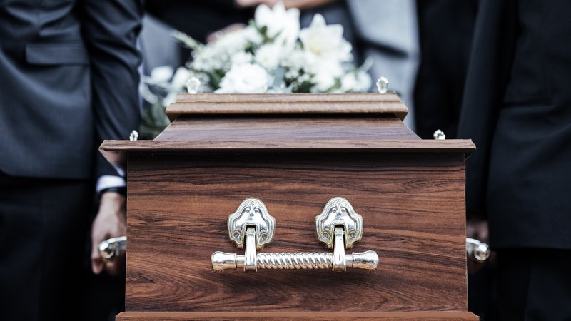 Männer tragen einen mit weißen Blumen geschmückten Sarg | Bild: colourbox.com Männer tragen einen mit weißen Blumen geschmückten Sarg