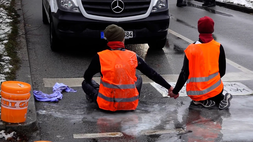 Zwei Klimaaktivisten blockieren eine Straße | Bild: BR Zwei Klimaaktivisten blockieren eine Straße
