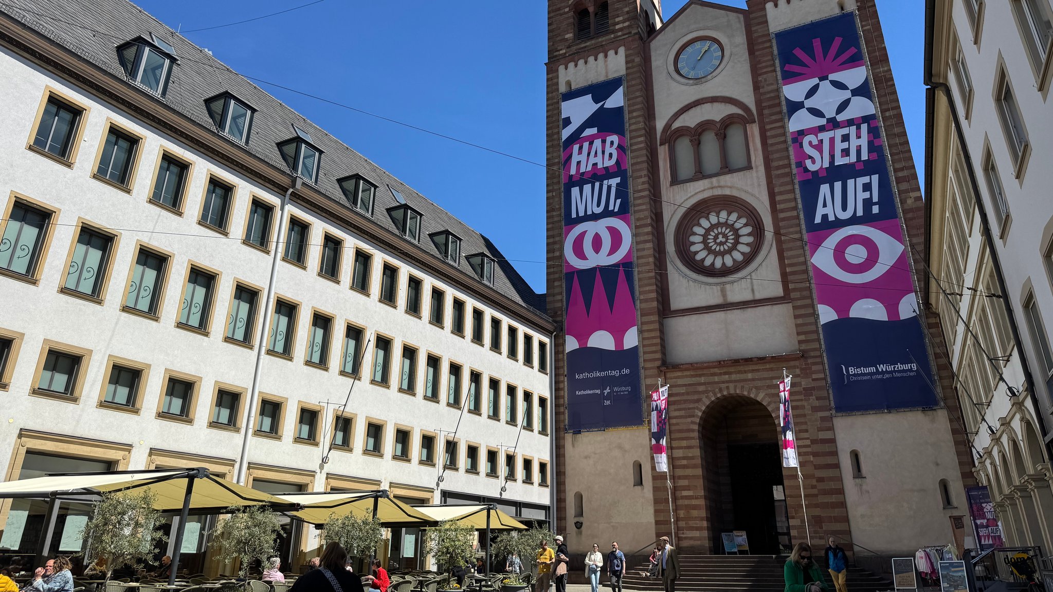 Zwei Banner an der Fassade des Würzburger Kiliansdoms mit Werbung für den 104. Deutschen Katholikentag.