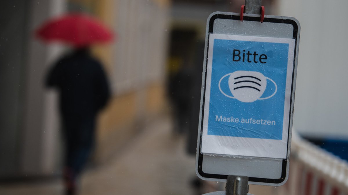 In einer schmalen Gasse in der Schweinfurter Innenstadt ist ein Schild aufgestellt, das auf die Maskenpflicht hinweist.