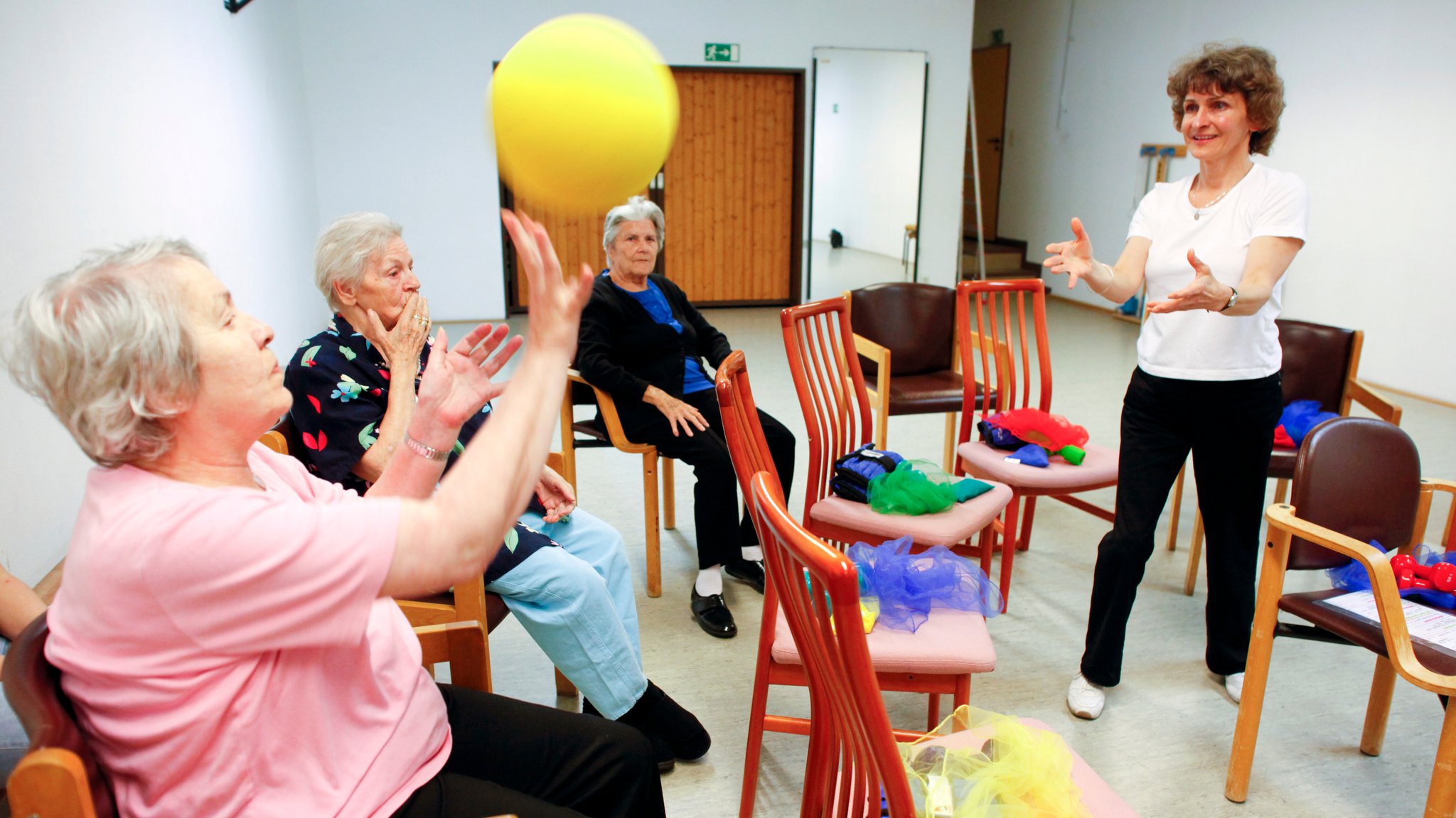 Eine Betreuerin spielt mit Heimbewohnern des AWO-Dorfs Hasenbergl mit einem Schaumstoffball.