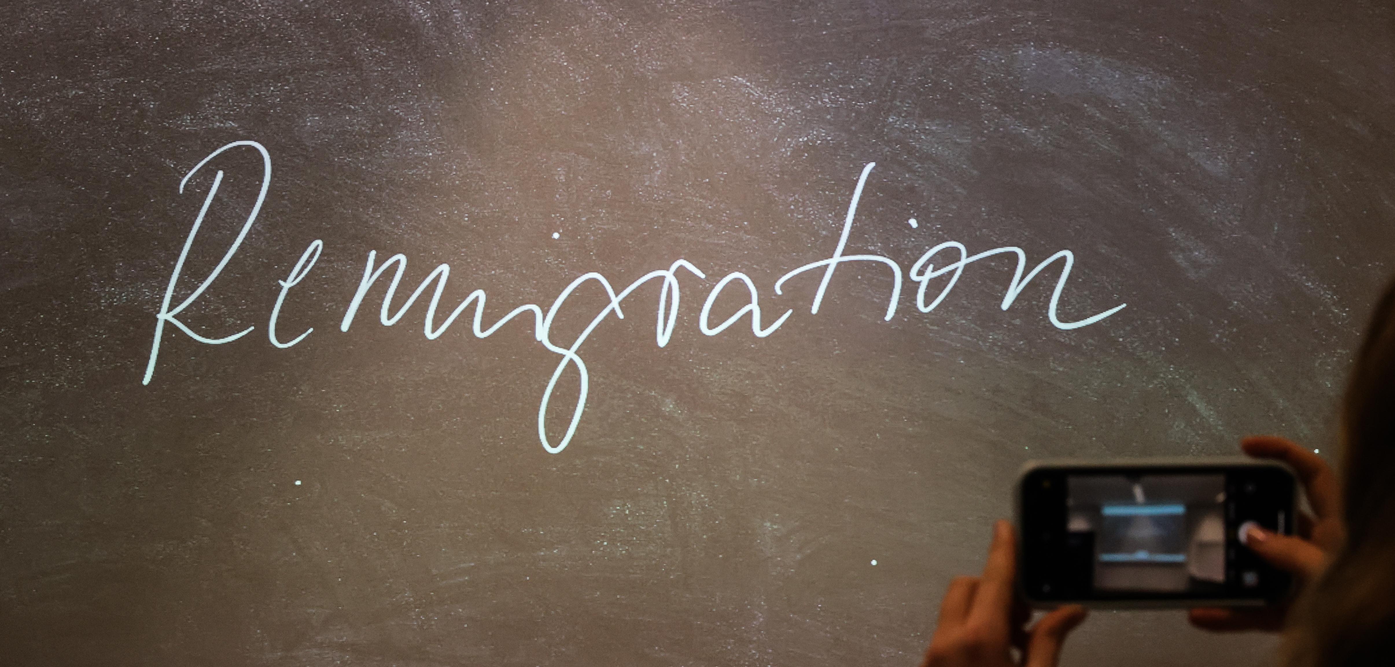 Der Begriff "Remigration" steht bei der Bekanntgabe des "Unwort des Jahres" 2023 auf einem Bildschirm.