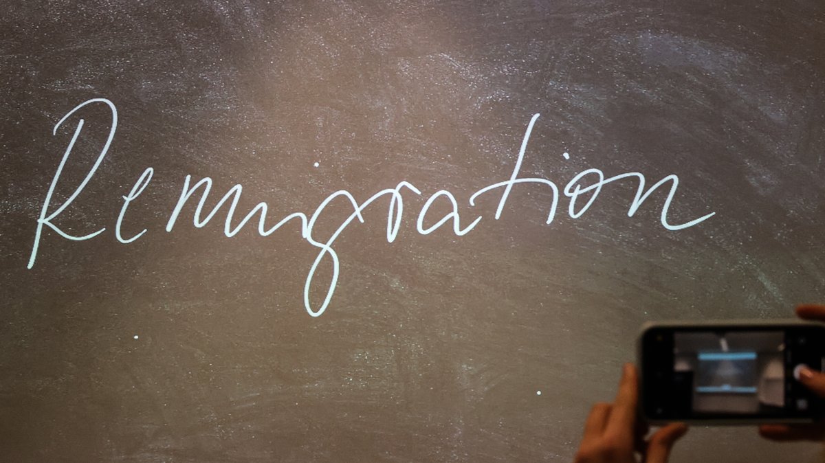 Der Begriff "Remigration" steht bei der Bekanntgabe des "Unwort des Jahres" 2023 auf einem Bildschirm.