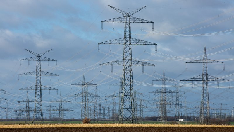 Symbolbild für Supraleitung: Stromleitungen führen zwischen Strommasten über Felder.