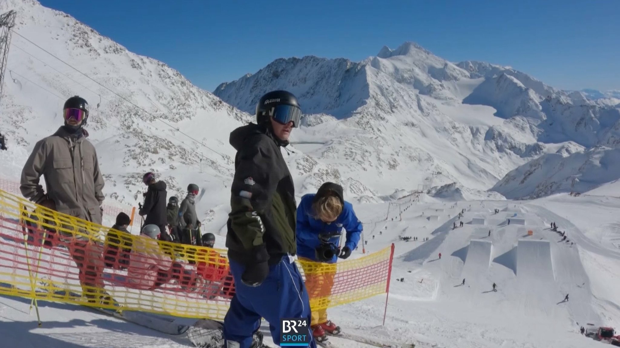 Snowboarder Noah Vicktor auf dem Snowboard und in Snowboard-Ausrüstung vor der Abfahrt auf eine Reihe von Sprungschanzen