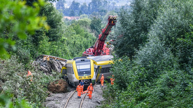 29.07.2025, Baden-Württemberg, Riedlingen: Mit einem Kran wird an der Unfallstelle, an der ein Regionalzug entgleist ist, ein Waggon angehoben. | Bild: dpa-Bildfunk/Jason Tschepljakow 29.07.2025, Baden-Württemberg, Riedlingen: Mit einem Kran wird an der Unfallstelle, an der ein Regionalzug entgleist ist, ein Waggon angehoben.