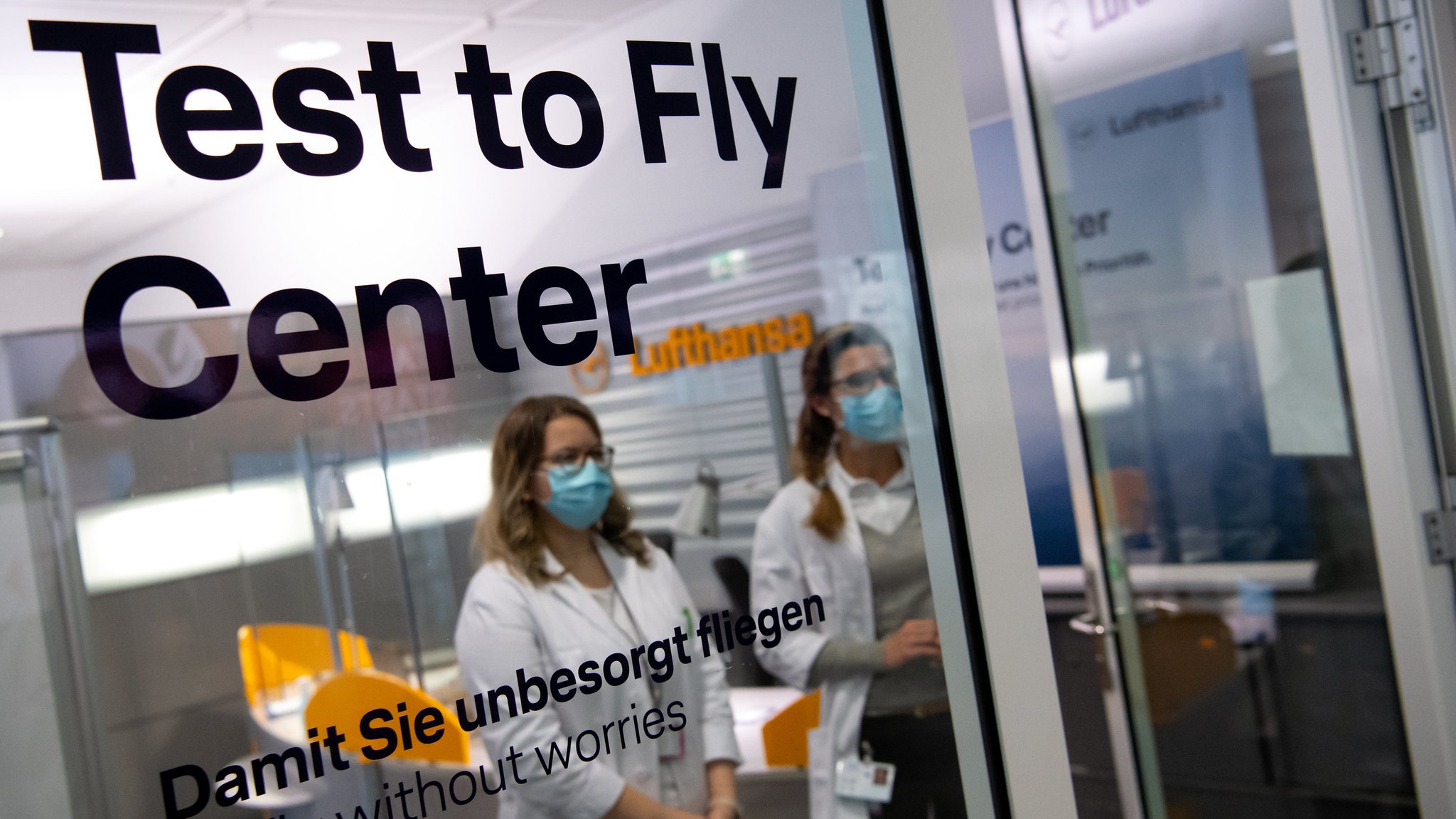 Medizinisches Personal steht am Flughafen München in einem Covid-19 Testcenter. 