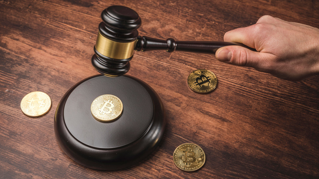 Bitcoin Verordnung und Regulierung. BTC Kryptomünze und Richter Hammer auf einem Schreibtisch