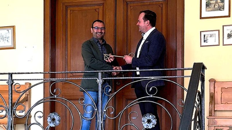 Zwei Männer übergeben einen Schlüssel. | Bild: BR/Ulrike Lefherz Zwei Männer übergeben einen Schlüssel.