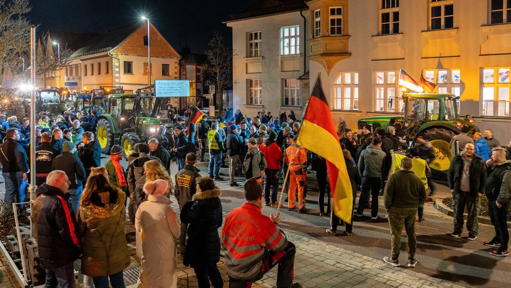 Protest in Hirschaid: Rechts das Gebäude, in dem am Mittwoch die Grünen-Versammlung stattfinden sollte, davor Demonstranten und Traktoren. | Bild:Picture Alliance/dpa/News5/Merzbach