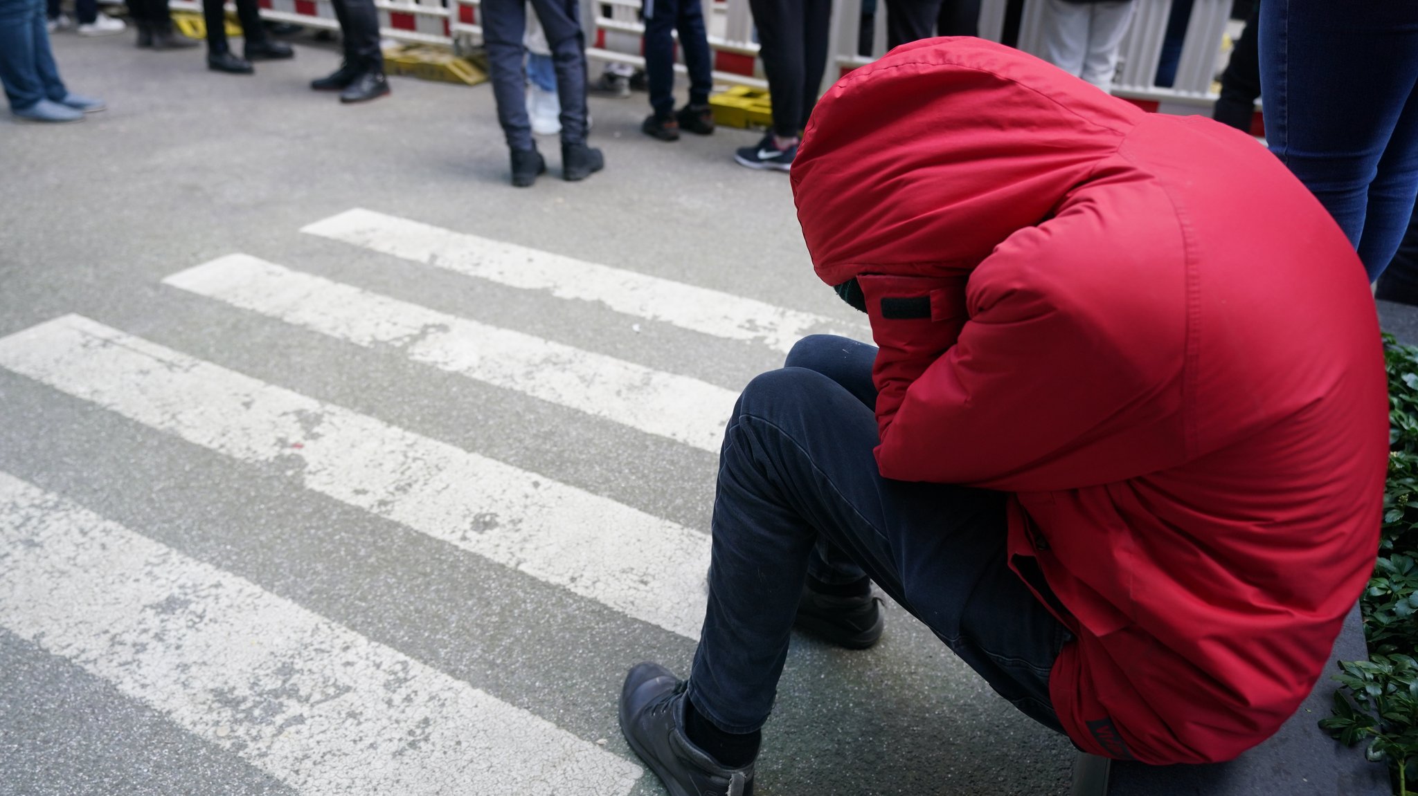 Ein ukrainischer Flüchtling sitzt vor der Zentralen Ausländerbehörde in Hamburg am 10. März auf der Straße.