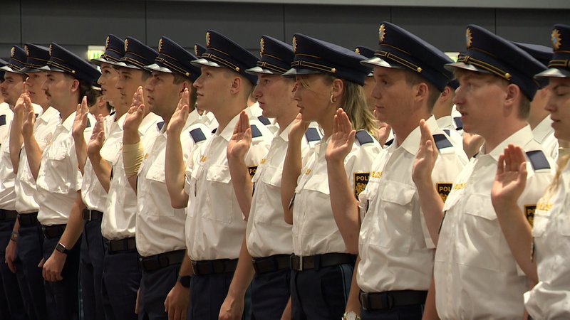 Polizistinnen und Polizisten in Uniform heben bei ihrer Vereidigung die rechte Hand. | Bild: BR Polizistinnen und Polizisten in Uniform heben bei ihrer Vereidigung die rechte Hand.